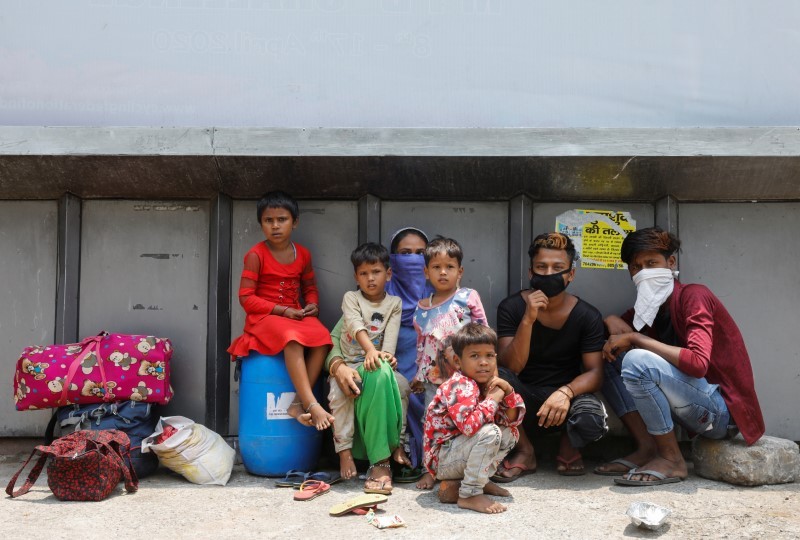 A family sits next to their belongings as they wait outside a railway station after a few restrictions were lifted during an extended nationwide lockdown to slow the spread of the coronavirus disease (COVID-19), in New Delhi, June 1, 2020. REUTERS/Adnan Abidi